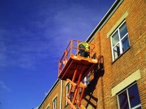 Technician carry out structural repairs from scissor lift