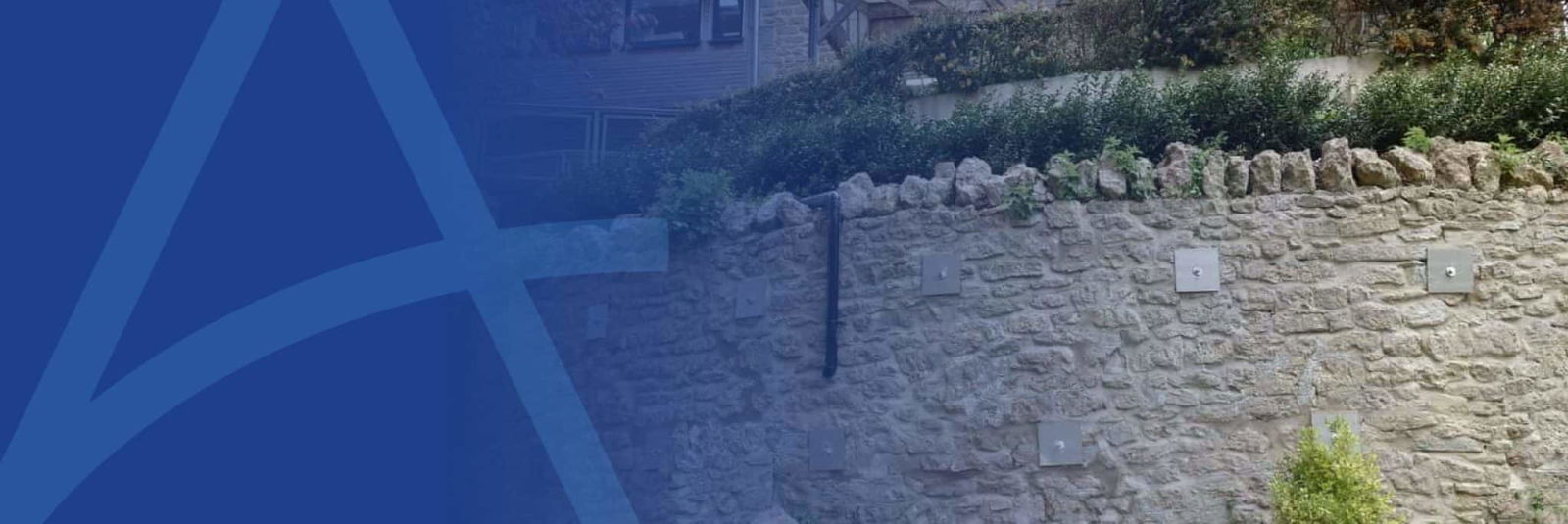 banner image showing stone retaining wall stabilised with ground anchors