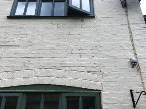 Cracking between windows of cottage